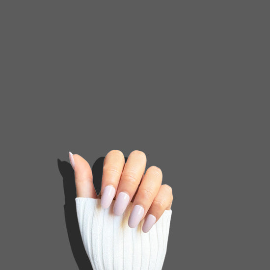 Fingers up pose showing de blinkie Bare Elegance soft pastel pink nude gloss press-on nails in short oval