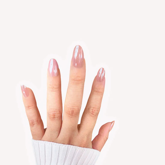 Fingers-up pose showing de blinkie Barely Mocha rosy mocha nude press-on nails in short oval shape against off-white background with white ribbed sleeve
