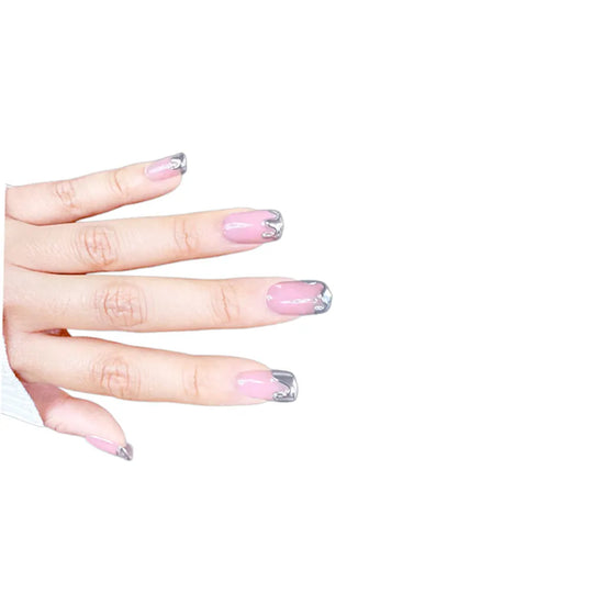 Diagonal hand pose showing de blinkie Chrome Whispers sheer blush pink with sculptural silver chrome tips in short square shape against white background with white ribbed knit sleeve