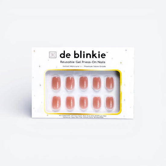 Product box shot of de blinkie Cinnamon Glaze warm cinnamon rose reusable gel press-on nails in short square displayed in white branded packaging with gold star detailing against a soft white background