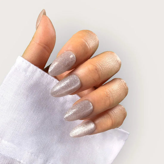 Claw pose close-up of Crystal Muse frosted icy silver ultra-fine shimmer short almond press-on nails against white background