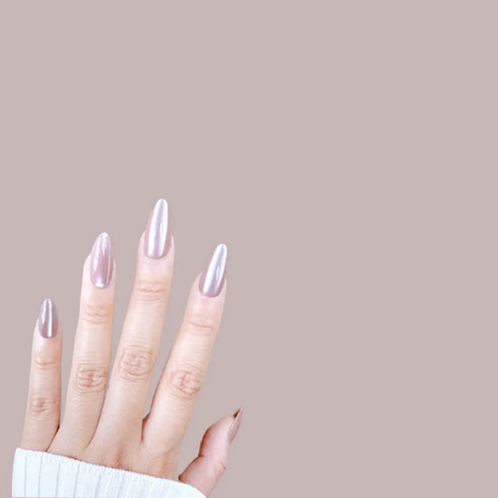 Horizontal spread hand showing de blinkie Dame Allure velvet mauve rose press-on nails in short almond against a warm mauve background with a white ribbed knit sleeve