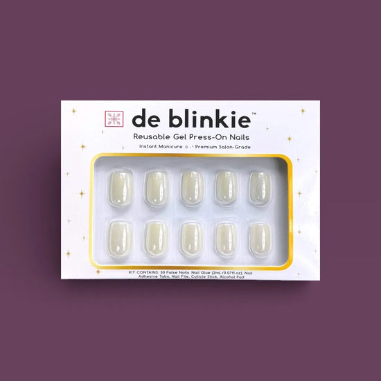 Box shot of de blinkie Glazed Milkyway reusable gel press-on nails in milk white gloss short square against a deep purple background