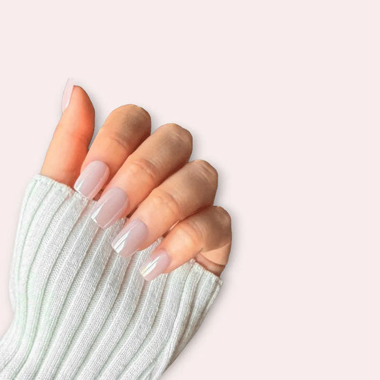 Claw pose showing de blinkie Glazed Petal luminous pearlescent rose mauve blush short square press-on nails against cream background
