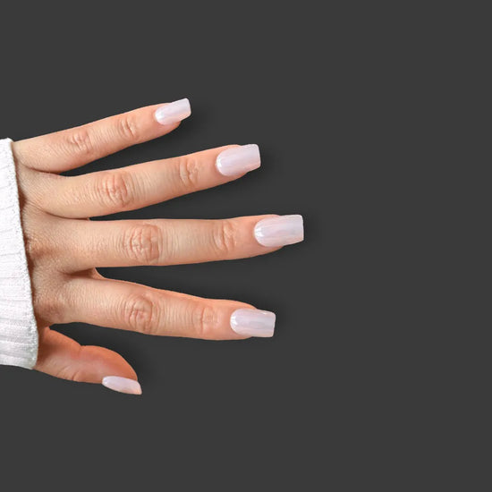 Horizontal spread hand showing de blinkie Glazed Petal rose mauve blush pearlescent glazed short square press-on nails against dark grey background