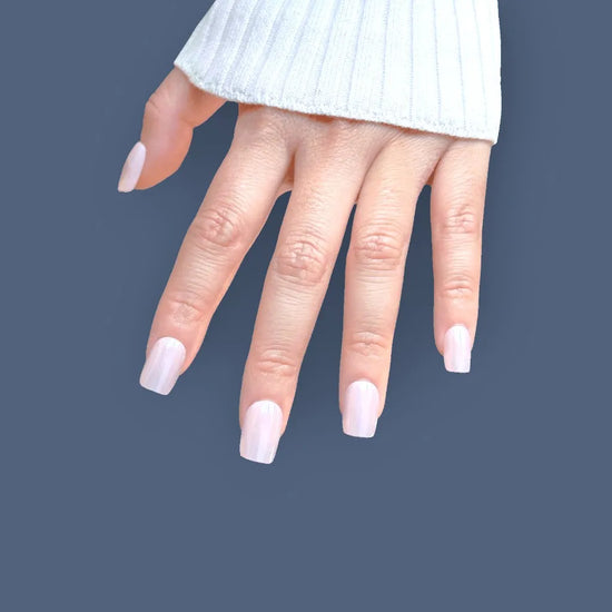 Fingers pointing down showing de blinkie Glazed Petal rose mauve blush glazed short square press-on nails against navy blue background