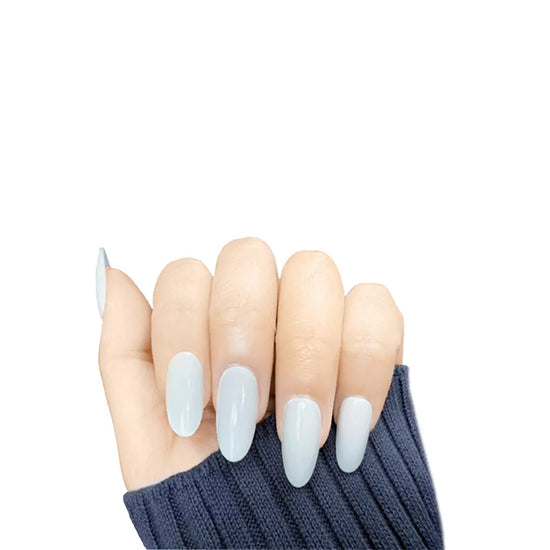Claw pose showing de blinkie Lady Ivory creamy milky white press-on nails in medium oval shape against white background with dark charcoal ribbed sleeve