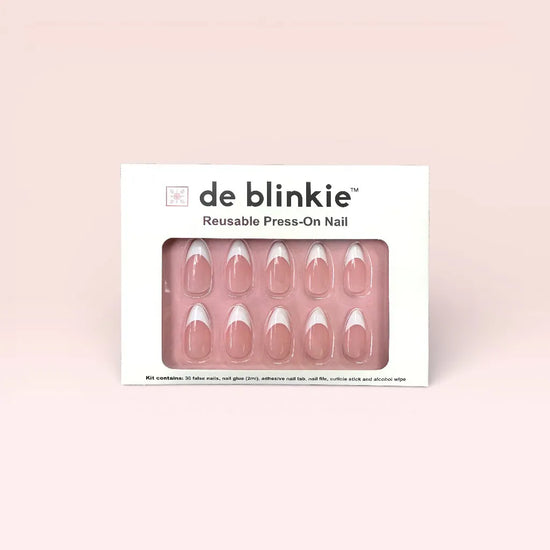 de blinkie Lady Primrose reusable press-on nail kit box showing 10 medium almond false nails with soft sheer pink base and bold white French tips on pink tray against soft pink background