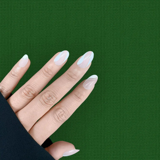 Spread hand showing Le Twist Blanc sheer pink nude with fluid white abstract sweep nail art in short oval shape against dark green background with black sleeve