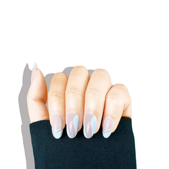 Claw pose showing de blinkie Le Twist Blanc sheer pink nude with white abstract sweep French tip design in short oval shape against white background with black sleeve