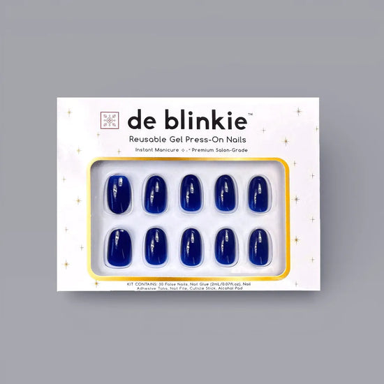 Product box shot showing de blinkie Midnight Reign cobalt blue gloss short oval press-on nails against a grey background