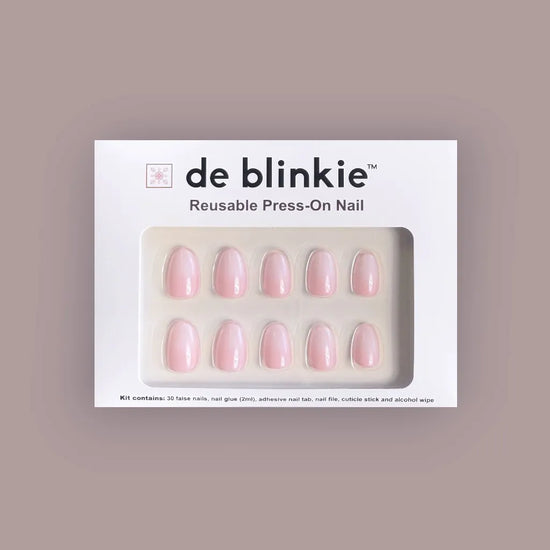 de blinkie Milky Kiss reusable press-on nail kit box showing 10 short oval false nails with soft milky pink finish on white tray against mauve background
