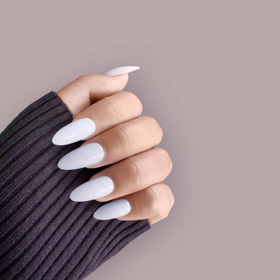 Claw pose close-up of de blinkie Miss Serene soft milky white soft gloss medium almond press-on nails against mauve background