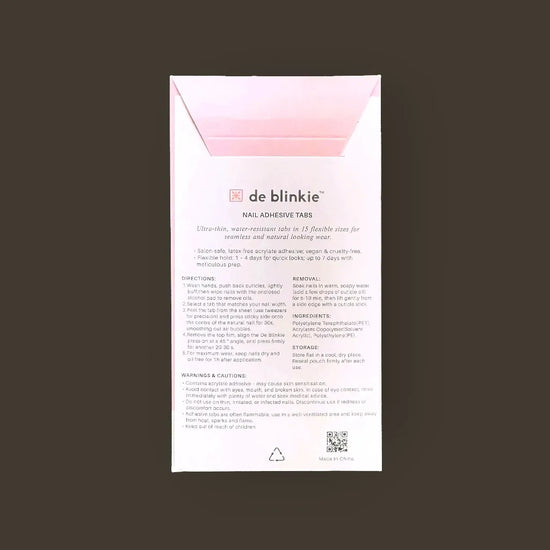 Back of de blinkie Nail Adhesive Tabs pack showing directions, ingredients and product details against a dark background