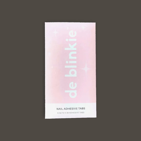 Front of de blinkie Nail Adhesive Tabs pack showing brand name against a soft pink background