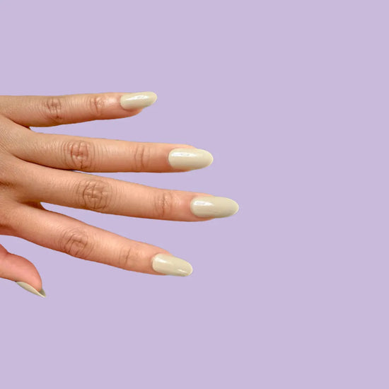 Side hand pose showing de blinkie Olive Dusk muted olive grey press-on nails in short oval against a lilac purple background