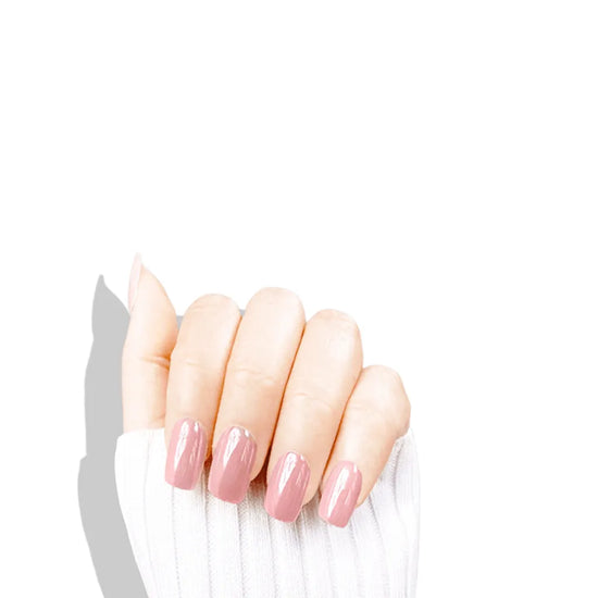 Claw pose showing de blinkie Pink Glimmer soft bubblegum pink glazed press-on nails in short square against a white background with a white ribbed knit sleeve