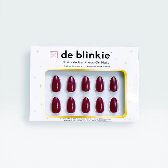 Product box shot showing de blinkie Plum Rouge deep plum burgundy gloss short almond press-on nails against a white background