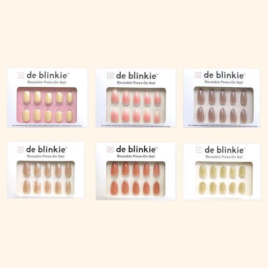 Box shot showing all six de blinkie Power Neutrals Edit muted pastel press-on nail styles against a cream background