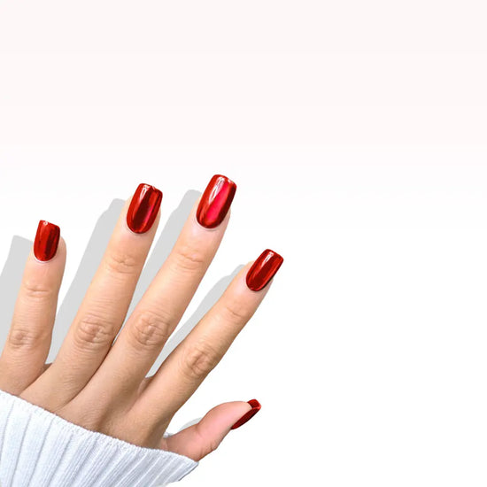 Fingers raised showing de blinkie Scarlet Luxe scarlet red mirror chrome press-on nails in short square against a light grey background