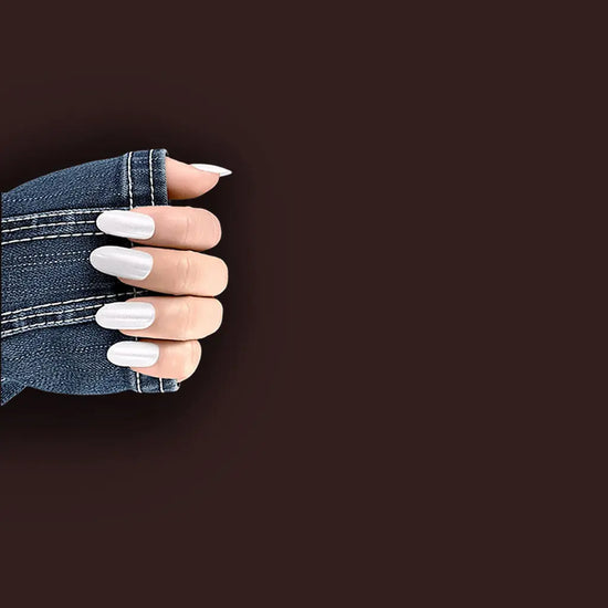 Claw pose with fingers pointing downward showing de blinkie Silver Glint pearl white pearlescent press-on nails in short almond