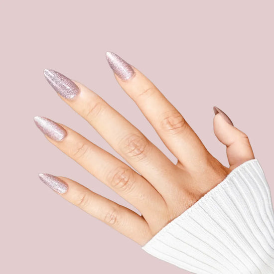 Side view of Starlight Sofia dusty rose pink shimmer short almond press-on nails catching light, pink background with white knit sleeve