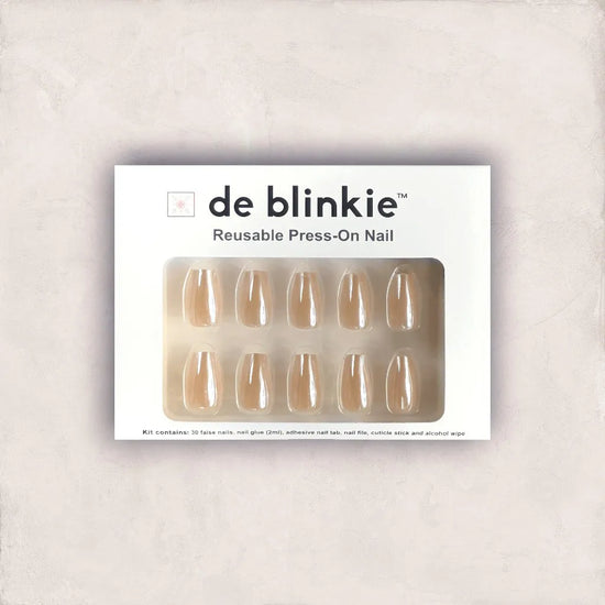 de blinkie The Executive Nude reusable press-on nail kit box showing 10 short coffin false nails with warm beige nude glazed finish on white tray against soft grey textured background