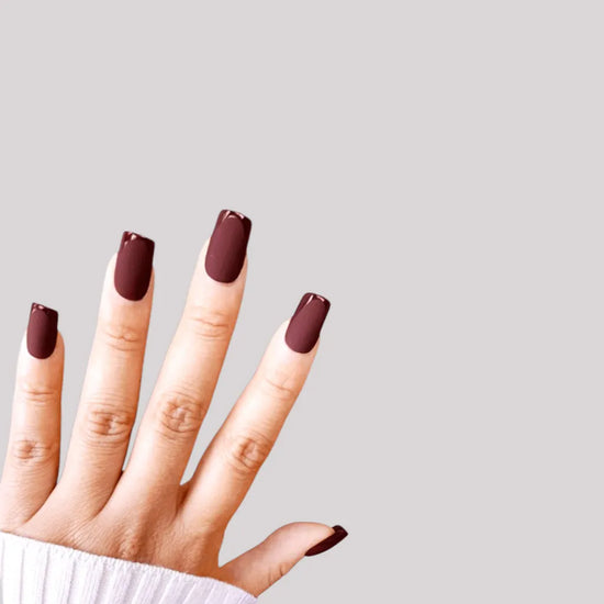 Fingers up pose showing de blinkie Velvet Bordeaux dark chocolate cherry velvet matte press-on nails in medium square shape against grey background with white ribbed knit sleeve
