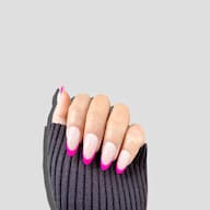Hand wearing fluer fuchsia hot pink french tip short almond press on nails from de blinkie